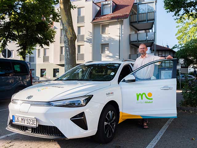 Robert Sauer steht bei Carsharing-Auto